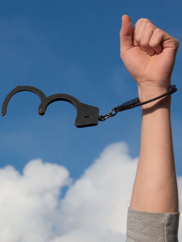 Hand met losse handboeien als symbool voor bevrijding van schaamte en schuld.